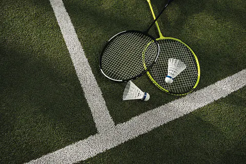Badminton rackets and shuttlecocks on a green court